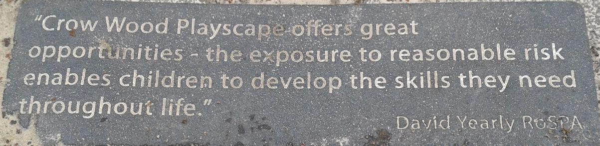 A slate engraved sign at a play park saying that if "offers great opportunities" and "the exposure to reasonable risk enables children to develop the skills they need throughout life" (a quote attributed to David Yearly of the Royal Society for the Prevention of Accidents). Photo by Sarah Fox